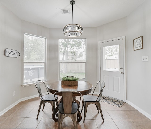 tiled dining space with a notable chandelier