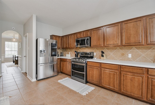 kitchen featuring appliances with stainless steel finishes, tasteful backsplash, and light tile patterned floors