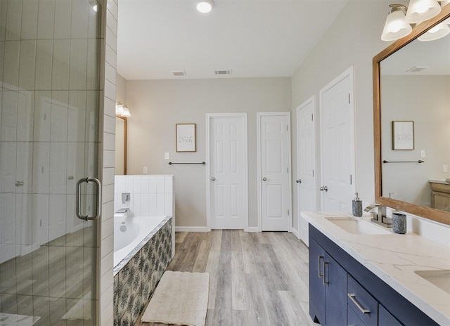 bathroom featuring vanity, hardwood / wood-style flooring, and separate shower and tub