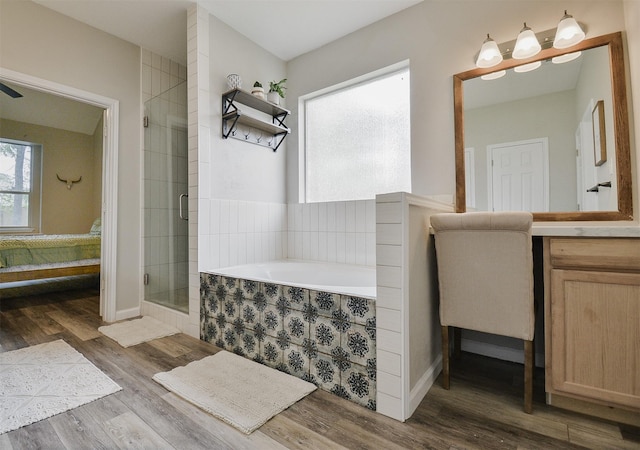 bathroom with hardwood / wood-style flooring, vanity, and separate shower and tub