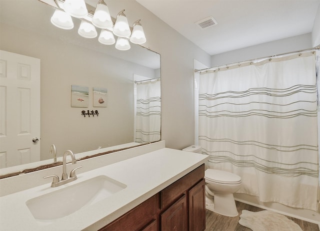 bathroom with hardwood / wood-style floors, vanity, and toilet