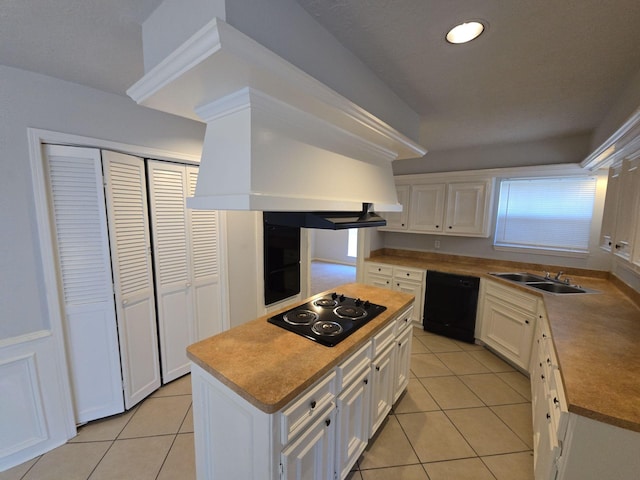 kitchen featuring premium range hood, black appliances, sink, a kitchen island, and white cabinetry