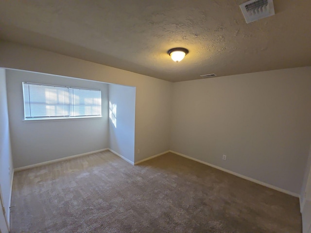 unfurnished room featuring carpet flooring and a textured ceiling