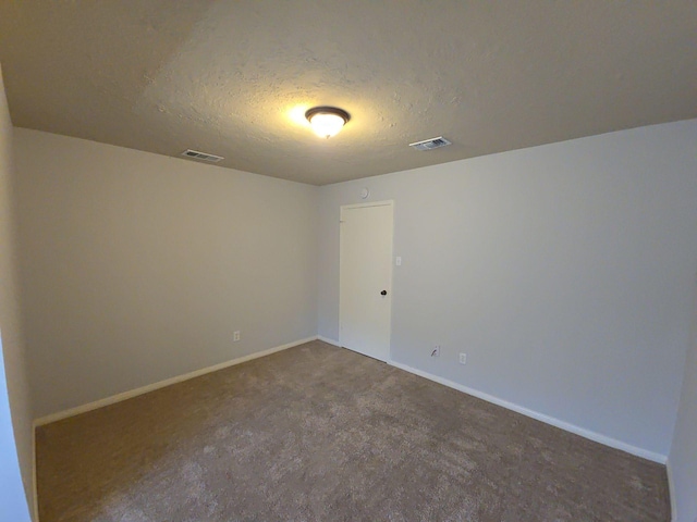 carpeted spare room featuring a textured ceiling