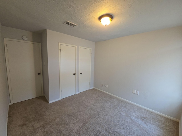 unfurnished bedroom featuring carpet flooring and a textured ceiling