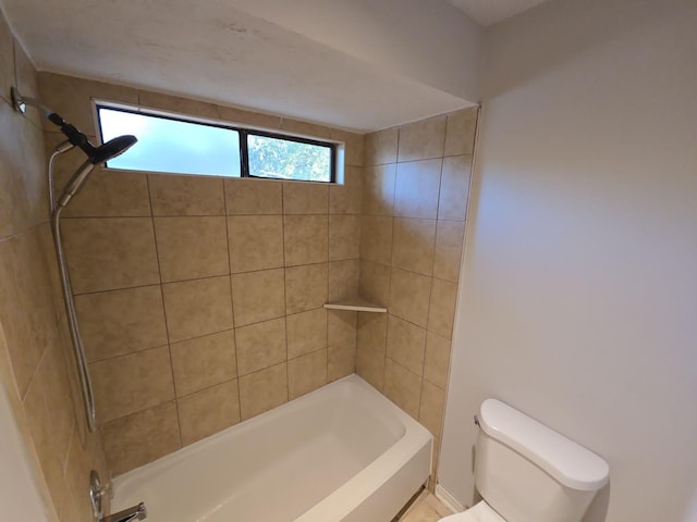 bathroom with toilet and tiled shower / bath