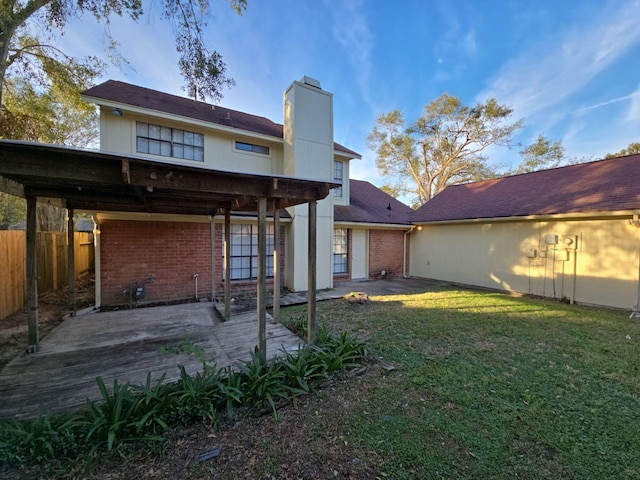 back of house featuring a lawn and a patio area