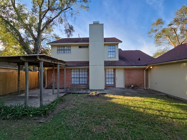 rear view of property featuring a patio area and a lawn