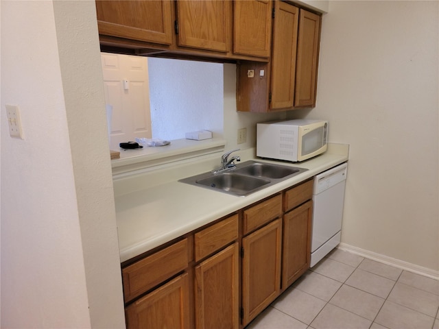 kitchen featuring sink, light tile patterned floors, and white appliances