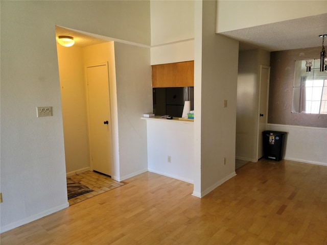 spare room featuring a textured ceiling and light wood-type flooring