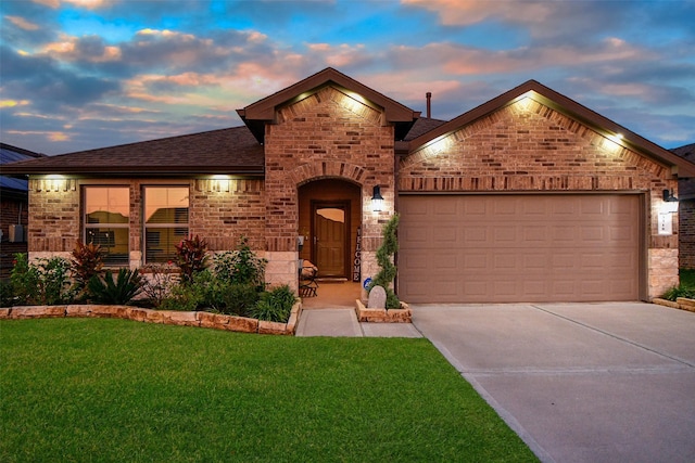 view of front of home with a yard and a garage