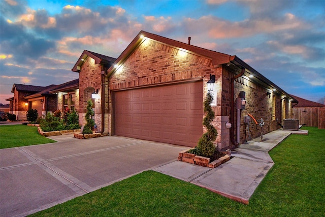 view of front of property with a yard, cooling unit, and a garage