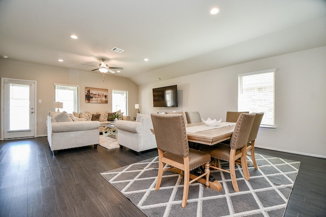 dining space with ceiling fan, dark hardwood / wood-style flooring, and vaulted ceiling