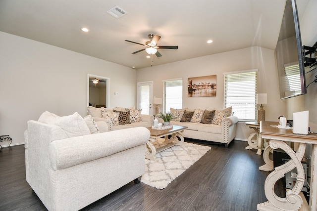 living room featuring ceiling fan and dark wood-type flooring