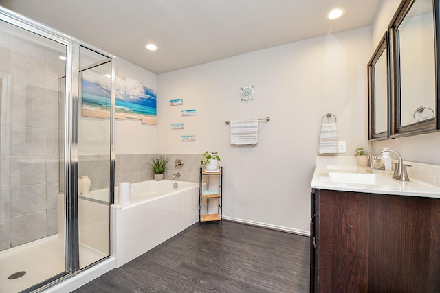 bathroom featuring vanity, wood-type flooring, and shower with separate bathtub