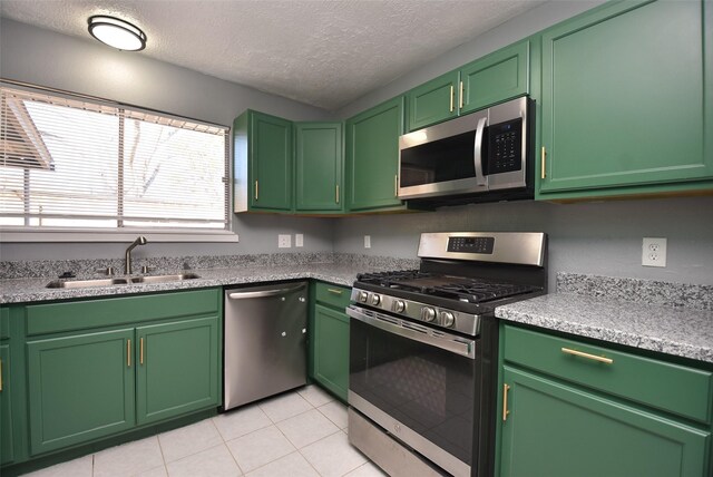 kitchen with green cabinets, sink, a textured ceiling, and appliances with stainless steel finishes