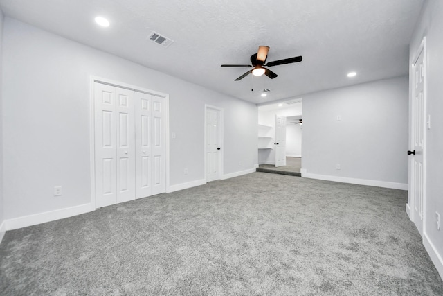 unfurnished bedroom with ceiling fan, carpet floors, and a textured ceiling