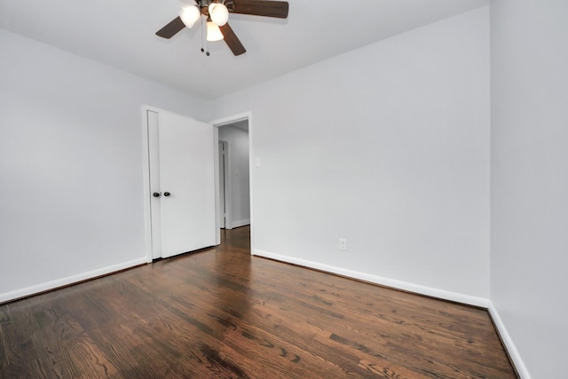 spare room featuring ceiling fan and dark wood-type flooring