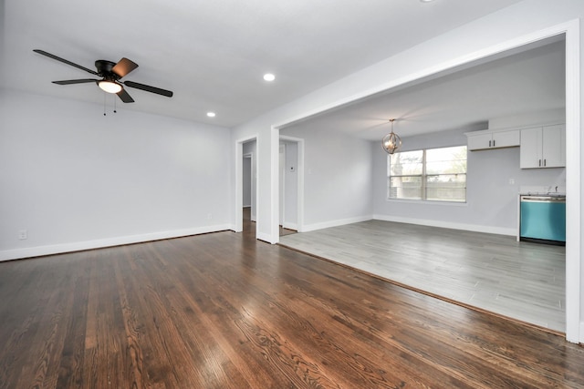 unfurnished living room featuring ceiling fan and dark wood-type flooring