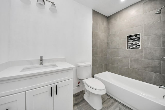 full bathroom featuring vanity, hardwood / wood-style flooring, toilet, and tiled shower / bath combo