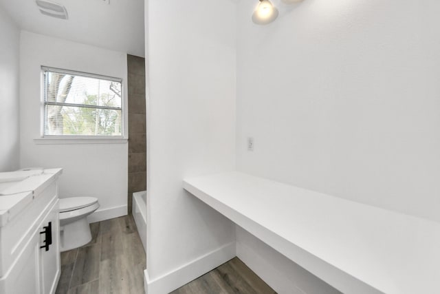 full bathroom featuring shower / bathing tub combination, hardwood / wood-style flooring, vanity, and toilet