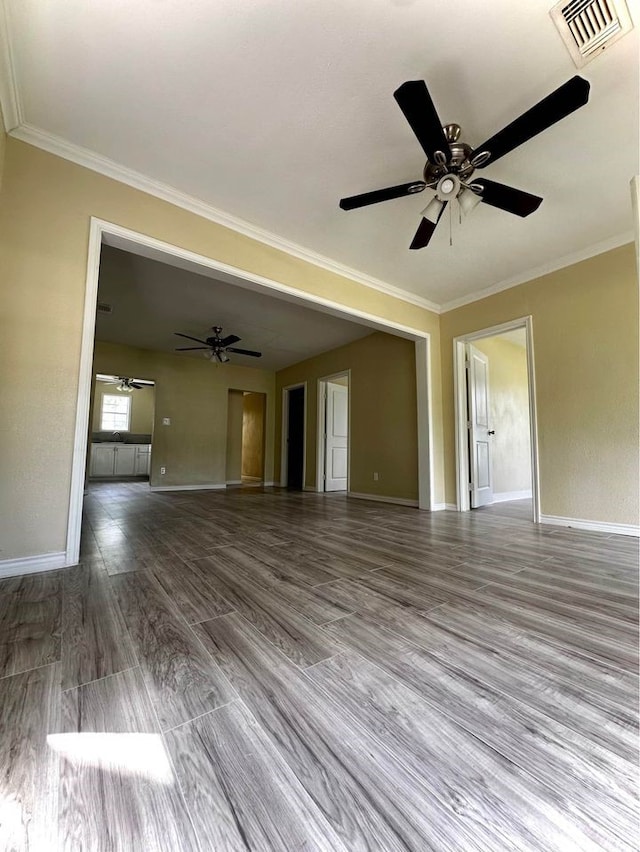 unfurnished living room featuring hardwood / wood-style flooring, ceiling fan, and ornamental molding