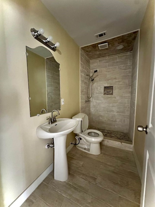 bathroom featuring toilet and tiled shower