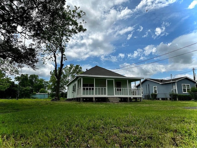 back of property with a lawn and covered porch