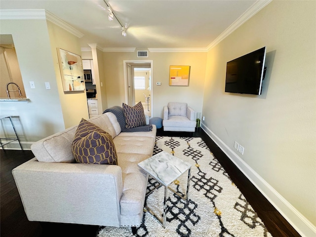 living room with track lighting, dark hardwood / wood-style floors, and ornamental molding