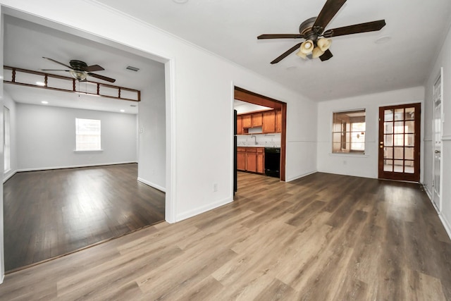 unfurnished living room with hardwood / wood-style floors, ceiling fan, and sink