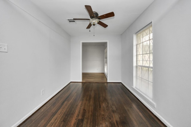 empty room with ceiling fan and dark wood-type flooring