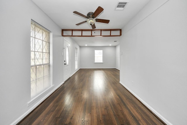 spare room featuring a wealth of natural light, dark wood-type flooring, and ceiling fan