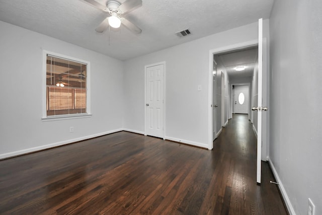 spare room featuring ceiling fan, dark hardwood / wood-style floors, and a textured ceiling