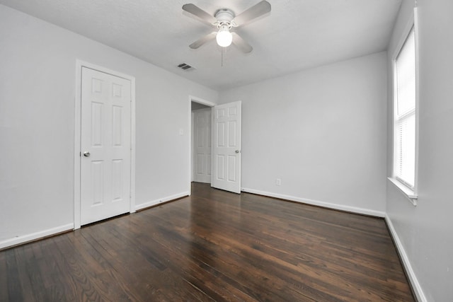 unfurnished bedroom with ceiling fan and dark hardwood / wood-style flooring