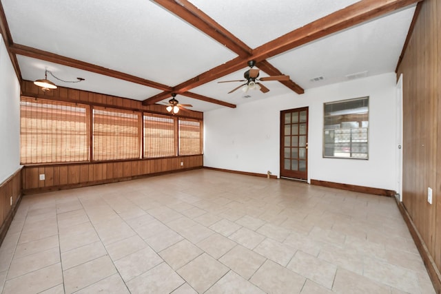 spare room featuring beamed ceiling, ceiling fan, wooden walls, and coffered ceiling