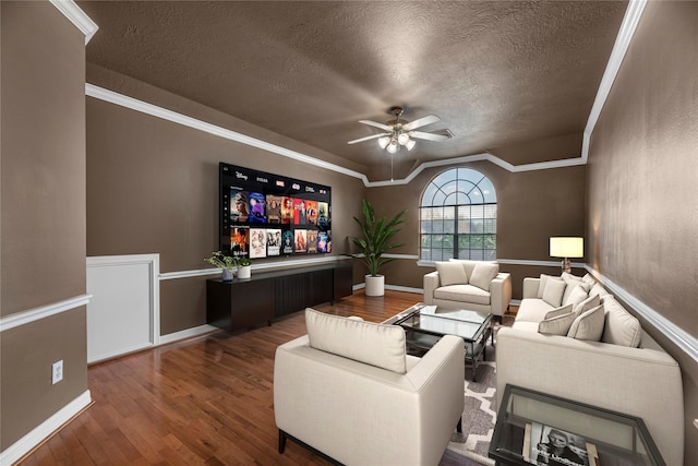 cinema room with hardwood / wood-style floors, a textured ceiling, ceiling fan, and ornamental molding