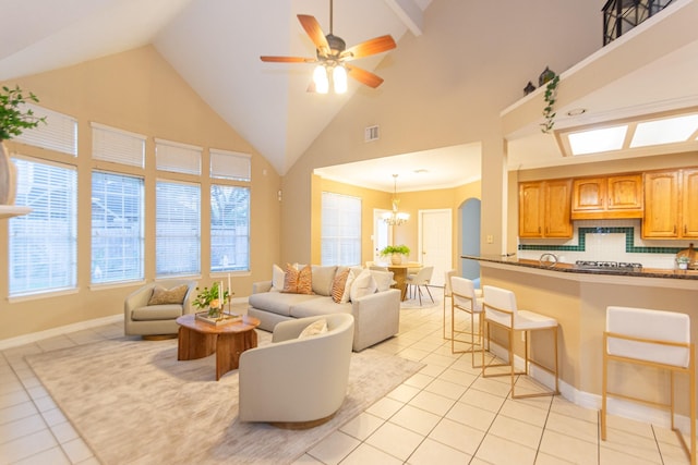 living room featuring ceiling fan with notable chandelier, light tile patterned floors, and high vaulted ceiling