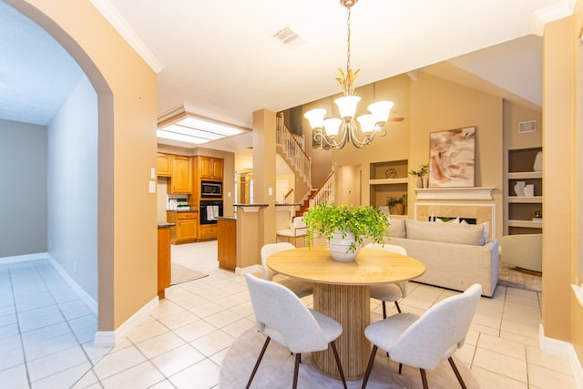 tiled dining area with crown molding, built in features, and a notable chandelier