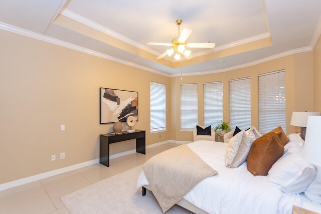 bedroom featuring a tray ceiling, ceiling fan, crown molding, and light tile patterned floors