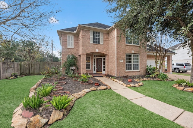 view of front facade featuring a garage, brick siding, a front yard, and fence