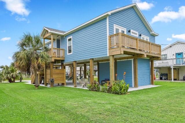 rear view of property with a wooden deck and a lawn