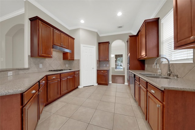 kitchen with appliances with stainless steel finishes, tasteful backsplash, ornamental molding, and sink