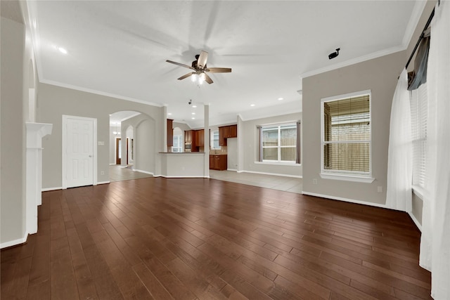 unfurnished living room featuring dark wood-type flooring, ceiling fan, and ornamental molding