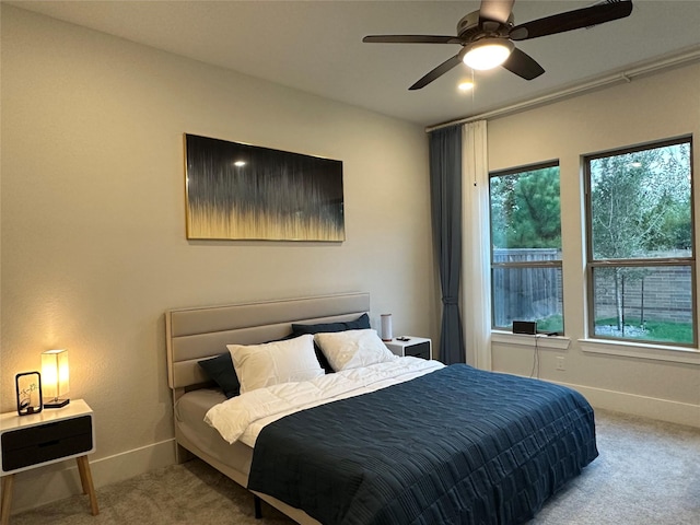 carpeted bedroom featuring multiple windows and ceiling fan