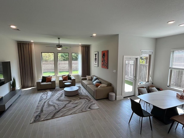 living room featuring ceiling fan and a healthy amount of sunlight