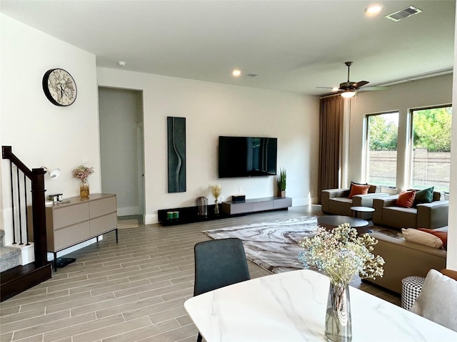 living room with ceiling fan and light hardwood / wood-style flooring