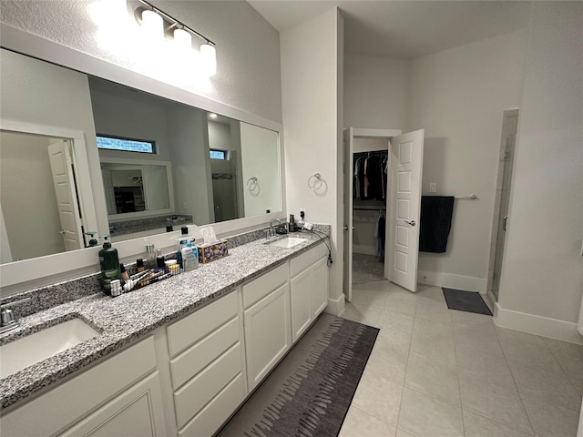 bathroom featuring tile patterned flooring, an enclosed shower, and vanity