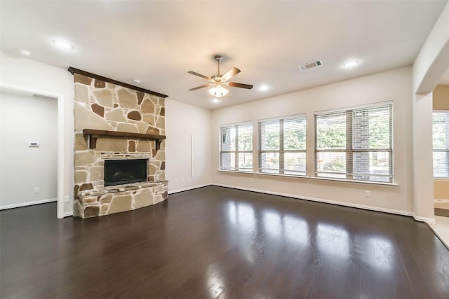 unfurnished living room featuring a stone fireplace, ceiling fan, and hardwood / wood-style flooring