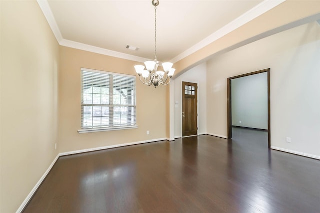 spare room featuring crown molding, dark wood-type flooring, and an inviting chandelier