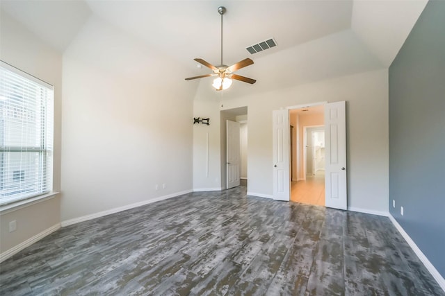 unfurnished bedroom featuring ceiling fan, dark hardwood / wood-style flooring, and vaulted ceiling